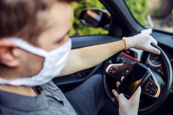 Άντρας Προστατευτική Μάσκα Και Γάντια Που Οδηγεί Αυτοκίνητο Κρατώντας Κινητό — Φωτογραφία Αρχείου