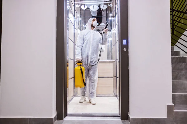 Sanitizing interior surfaces. Cleaning and Disinfection inside buildings, the coronavirus epidemic. Professional teams for disinfection efforts. Infection prevention and control of epidemic. Protective suit and mask.
