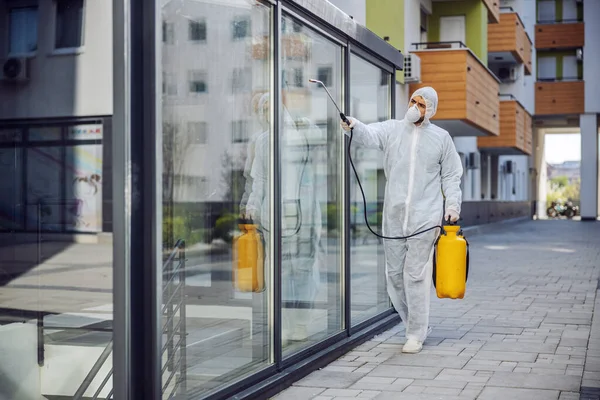 Cleaning and Disinfection outside around buildings, the coronavirus epidemic. Professional teams for disinfection efforts. Infection prevention and control of epidemic. Protective suit and mask. Professional specialist full protective cleaning outsid