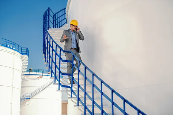 Серьезный Привлекательный Кавказский Элегантный Бизнесмен Костюме Шлемом Голове Спускающийся Лестнице — стоковое фото