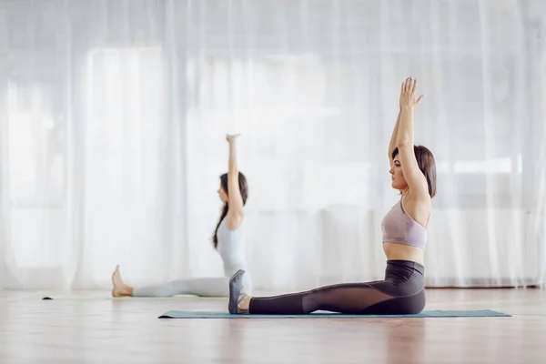 Dos Hermosas Chicas Forma Sentadas Alfombra Estudio Yoga Haciendo Ejercicios —  Fotos de Stock