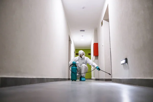 Trabalhador Terno Estéril Máscara Agachando Corredor Edifício Esterilizando Corona Vírus — Fotografia de Stock