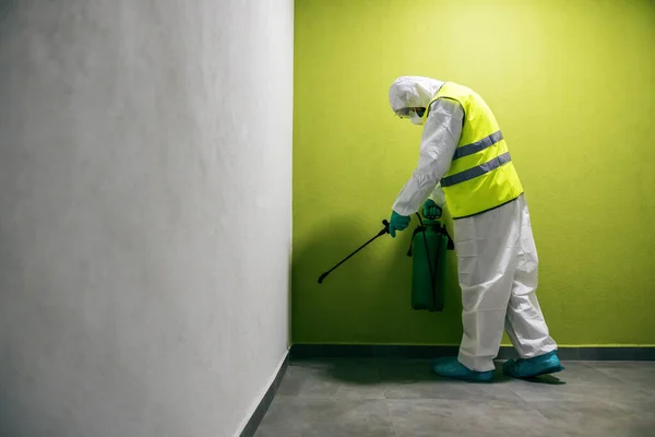 コロナウイルス Covid 19の建物の滅菌スーツとベスト滅菌ホールでの労働者の完全な長さ — ストック写真