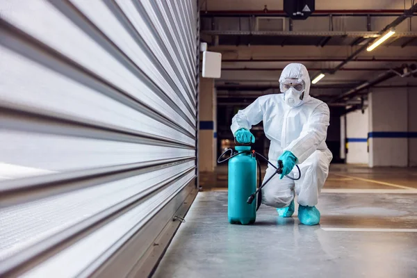 コロナウイルス Covid 19からガレージの滅菌保護スーツとマスク滅菌ドアの労働者の完全な長さ — ストック写真