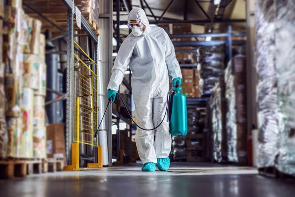 コロナウイルス Covid 19食品の完全な保護スーツとマスク消毒倉庫の男 — ストック写真