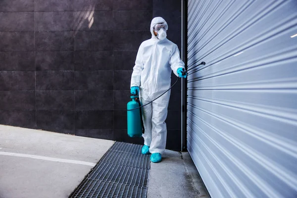 男で保護滅菌制服とマスク滅菌ガレージドアからコロナウイルス 病気や真菌 — ストック写真
