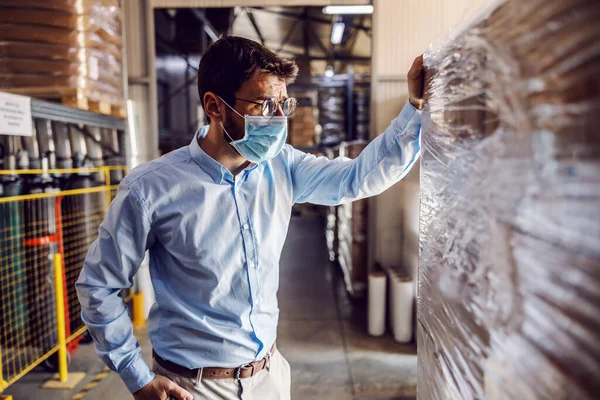 若い魅力的なビジネスマン保護滅菌マスクを着用し 梱包品をチェックアウト — ストック写真