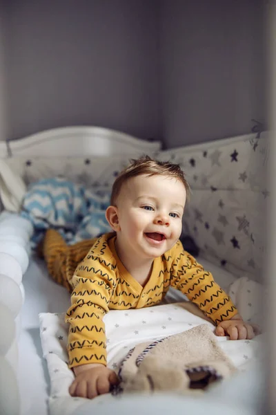 Bebe Blond Souriant Mignon Et Joyeux Avec De Beaux Yeux Bleus Allonges Sur Le Ventre Dans Son Berceau Le Matin Et Se Reveillant Garcon Joie Stock Photo