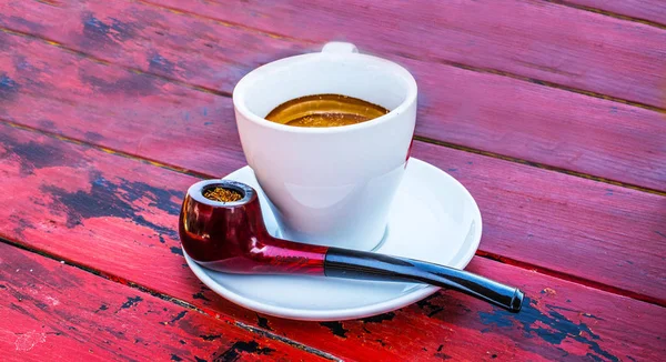 Rote Pfeife und Espresso auf rotem Tisch — Stockfoto