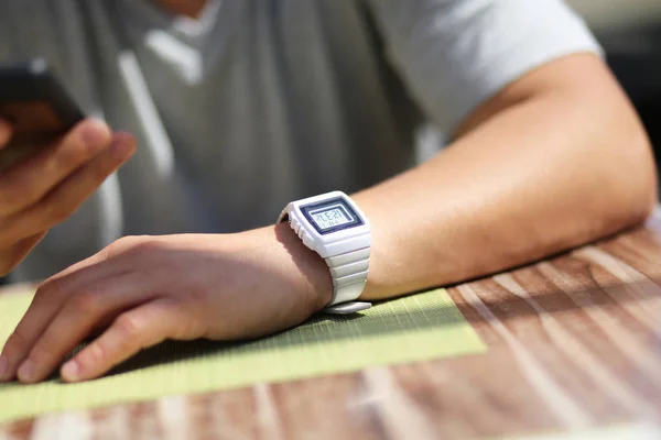 Mann mit klassischer alter elektronischer Retro-Armbanduhr und Handy — Stockfoto