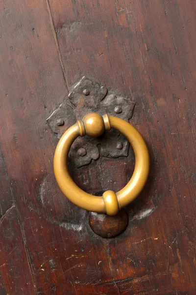 Bronze metal antique vintage door knock or knocker on an old woo