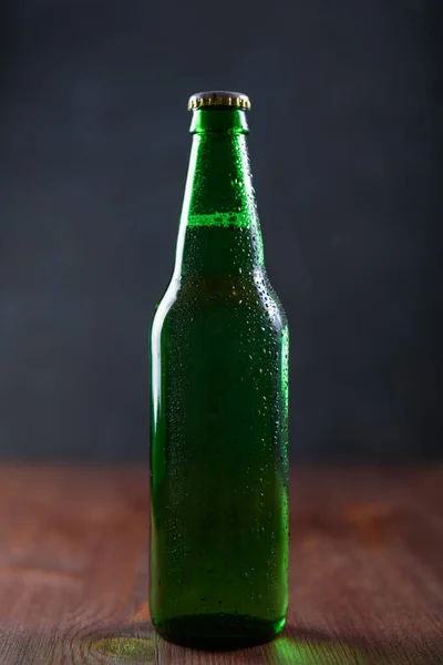 Cerveja Uma Garrafa Verde Com Gotas Água Mesa Madeira Fundo — Fotografia de Stock