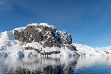 Kayalar ve karla kaplı Antarktika manzarası