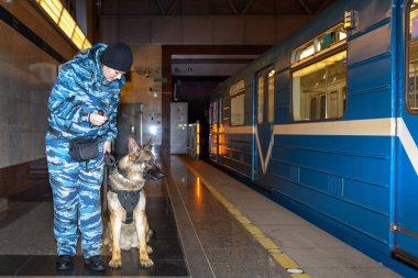Eğitimli bir Alman çoban köpeği olan kadın polis memuru ya uyuşturucunun kokusunu alır ya da bagajdaki bombayı. Metro istasyonu..
