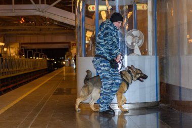 Eğitimli bir Alman çoban köpeği olan kadın polis memuru ya uyuşturucunun kokusunu alır ya da bagajdaki bombayı. Metro istasyonu..