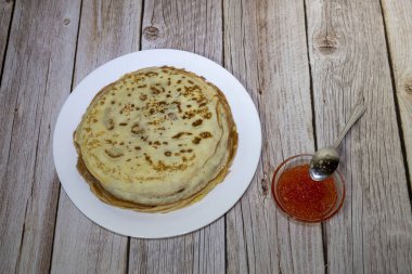 Kırmızı havyarlı, koyu kırsal arka planda bir yığın ince krep.