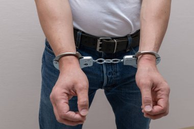 Adult prisoner male hands with handcuffs. Arrested man. Criminal concept.