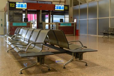 Passenger seats in Departure lounge in airport terminal, travel concept