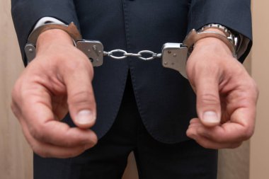 Arrested businessman or official in handcuffs. Corruption or economic crime concept.