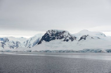Buzullu ve dağlı Antarktika plajı, keşif gemisinden manzara