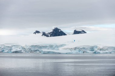Buzullu ve dağlı Antarktika plajı, keşif gemisinden manzara
