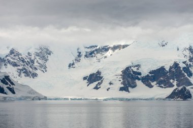 Buzullu ve dağlı Antarktika plajı, keşif gemisinden manzara