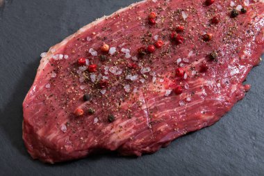 Koyu arka planda çiğ mermer et ve baharatlar.