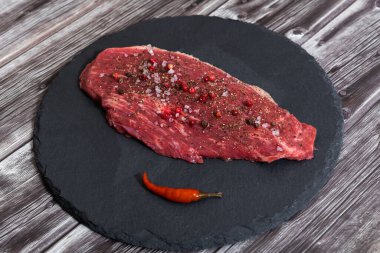 Koyu arka planda çiğ mermer et ve baharatlar.