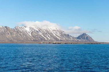 Yaz mevsiminde Svalbard 'da dağ ve bulutlarla kutup manzarası