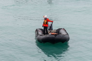 Kuzey Kutbu sularında bir kişiyle birlikte şişme tekne (Zodiac), Svalbard.