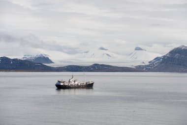 Svalbard 'da güzel ışıklandırması olan küçük yelkenli gemi.