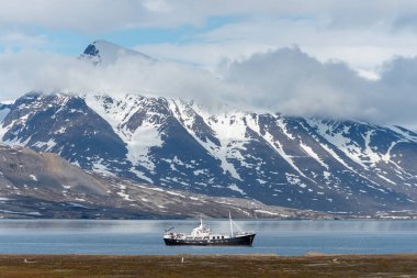 Svalbard 'da güzel ışıklandırması olan küçük yelkenli gemi.