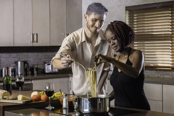 dinner preparation  kitchen cooking happy young mixed race coupl