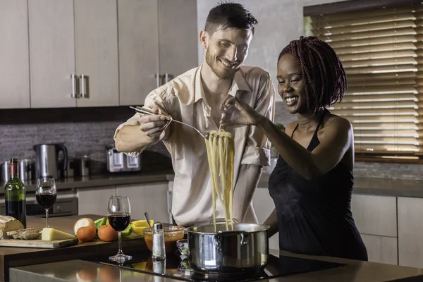 dinner preparation  kitchen cooking happy young mixed race coupl