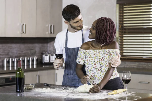 Счастливая пара смешанных рас смешивает тесто на кухне — стоковое фото