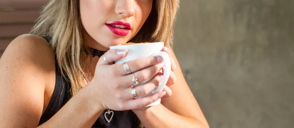 Attractive woman drinking a hot beverage — Stock Photo, Image
