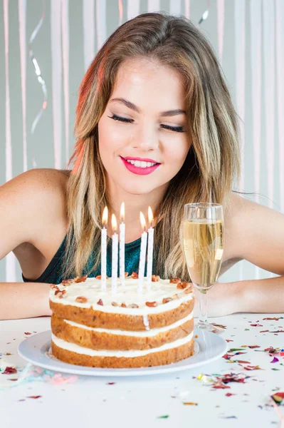 Menina bonita olhando velas acesas no bolo de aniversário para comemorar — Fotografia de Stock