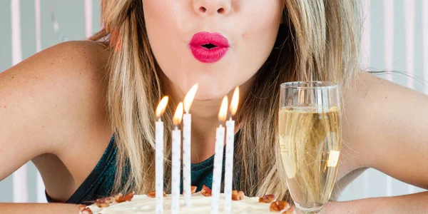 Hübsches Mädchen bläst Festkerzen auf leckerem Kuchen aus — Stockfoto