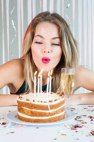 Linda chica soplando velas de celebración en delicioso pastel —  Fotos de Stock