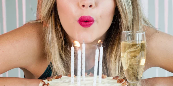 Csinos lány elfújta ünnepi gyertyák a finom sütemény — Stock Fotó