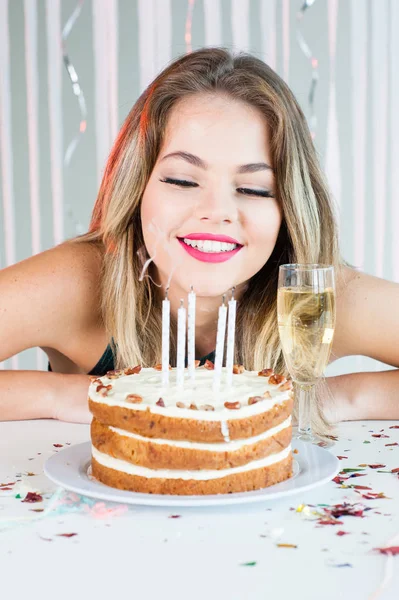 Menina bonita olhando velas acesas no bolo de aniversário para comemorar — Fotografia de Stock