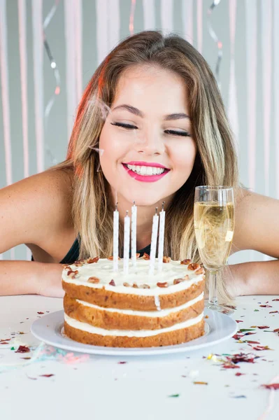 Menina bonita olhando velas acesas no bolo de aniversário para comemorar — Fotografia de Stock