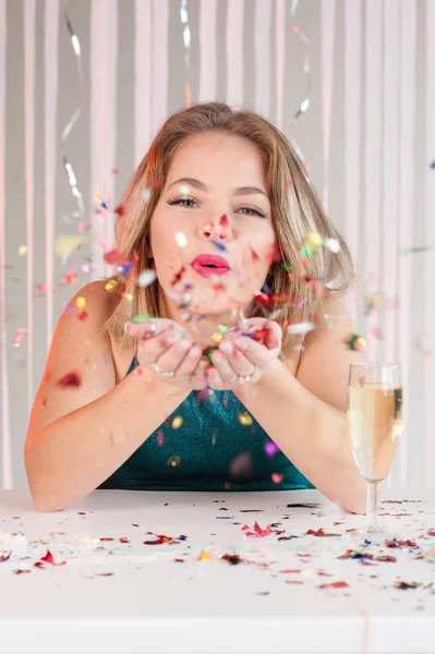 Šťastná dívka foukání barevné třpytky na večírku — Stock fotografie