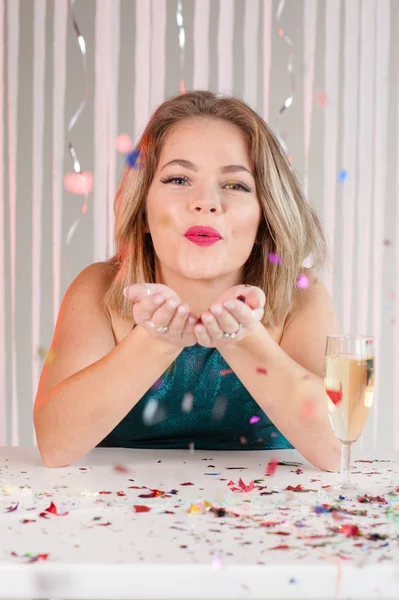 Fröhliches Mädchen bläst auf einer Party buntes Glitzern — Stockfoto