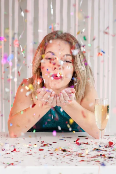 Chica feliz soplando brillo colorido en una fiesta —  Fotos de Stock