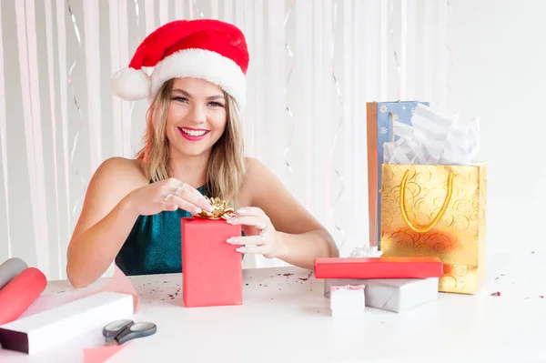 Mooi meisje in Christmas hat wrapping aanwezig Rechtenvrije Stockfoto's