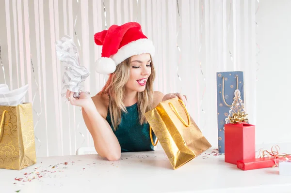 Hübsches Mädchen mit Weihnachtsmützenöffnung verpackt Geschenk Stockbild