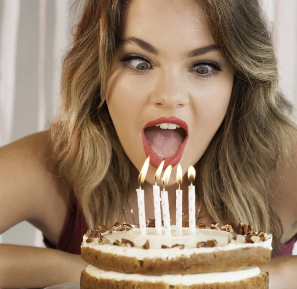 Jonge aantrekkelijke verjaardag meisje uitblazen van de kaarsjes op een cak — Stockfoto