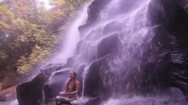 kız ve şelale ve bambu ormanda yoga
