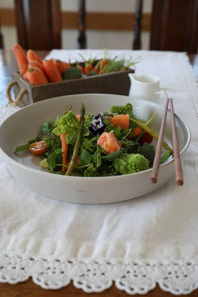 Salat mit Gemüse und Lachs mit chinesischen Sticks lizenzfreie Stockbilder